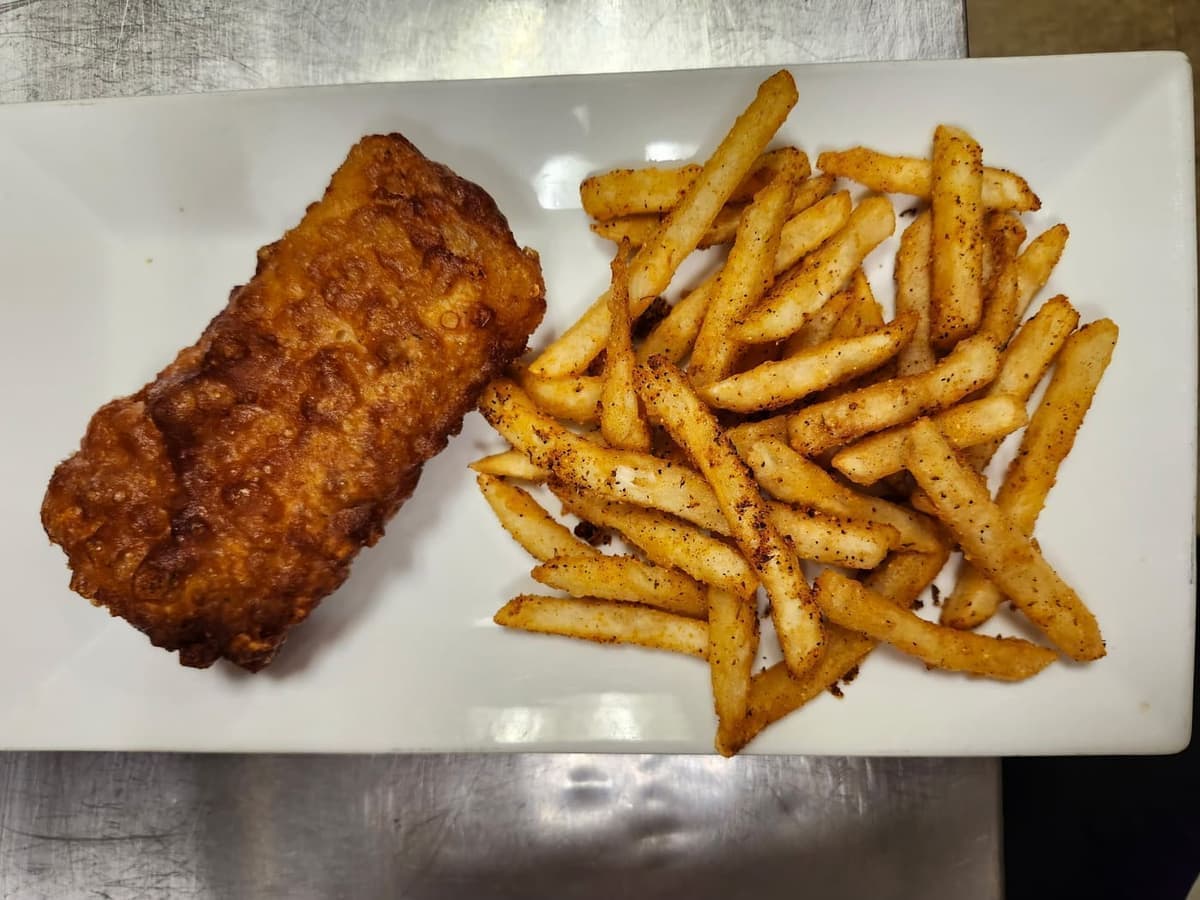 A golden beer-battered fish fillet beside seasoned french fries on a white rectangular plate